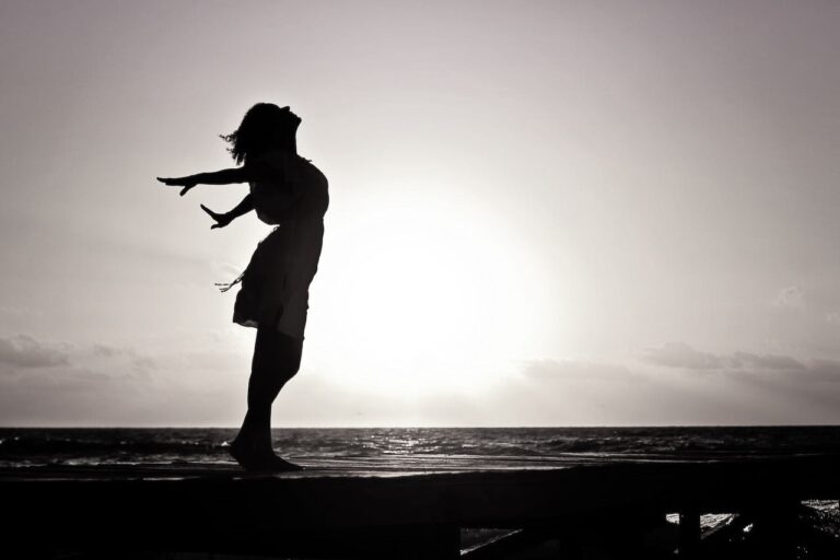 a happy woman by the sea, during sunset