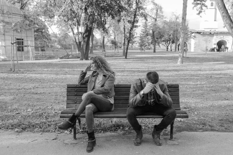 A couple on a bench arguing.