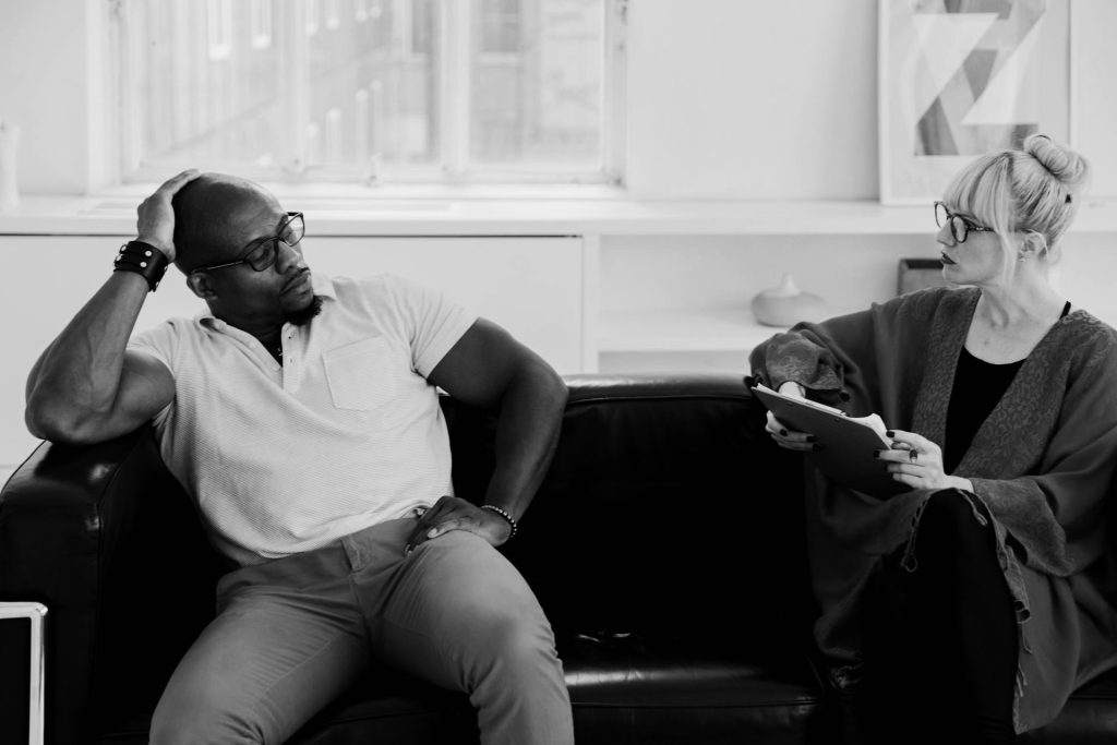 Couple in tense conversation on couch.
